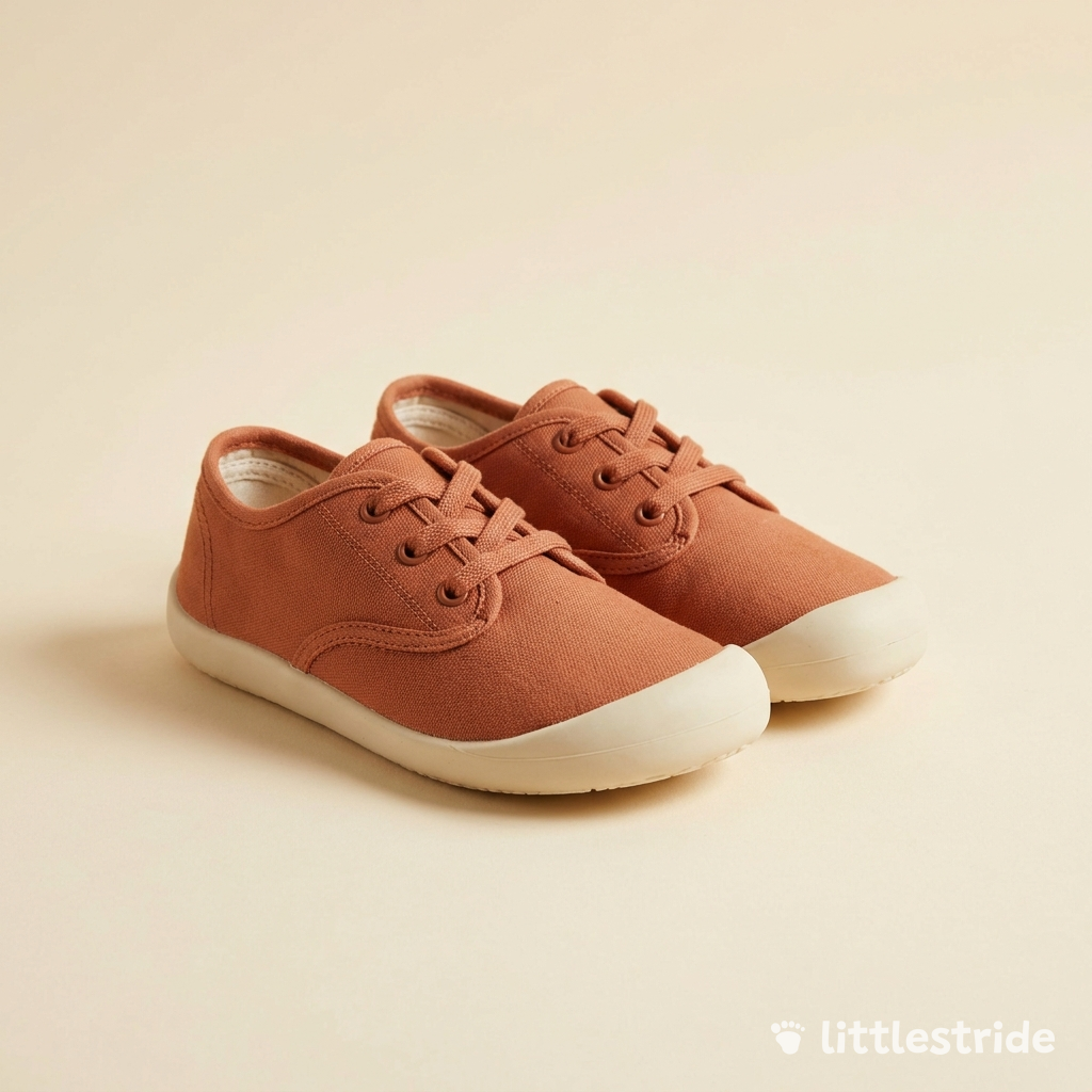 Littlestride barefoot sneakers in terracotta canvas on a cream studio backdrop